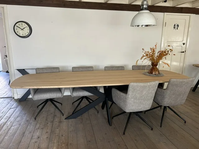 Deens ovaal eiken eettafel met zwarte stalen poten en grijze stoelen in onze showroom in Veghel